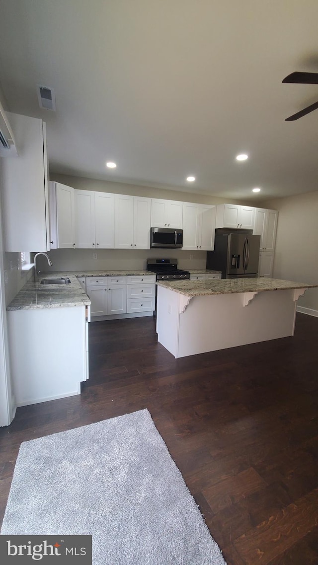kitchen with a sink, visible vents, white cabinets, and stainless steel appliances