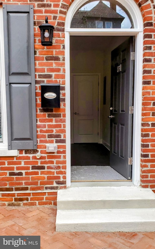 doorway to property featuring brick siding