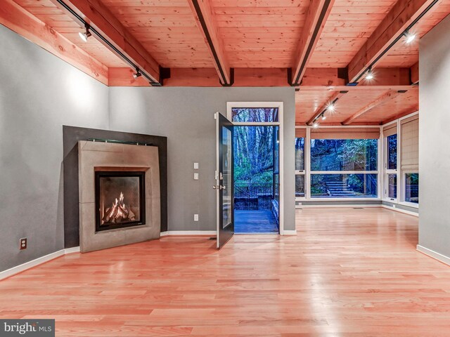 3411 Woodberry Ave, Baltimore, MD 21211 - unfurnished living room with rail lighting, a warm lit fireplace, wood ceiling, wood finished floors, and beam ceiling