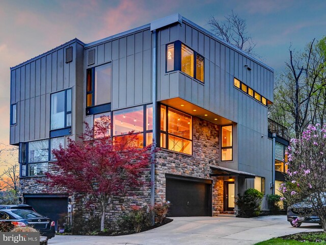 3411 Woodberry Ave, Baltimore, MD 21211 - modern home featuring a garage, driveway, stone siding, and board and batten siding
