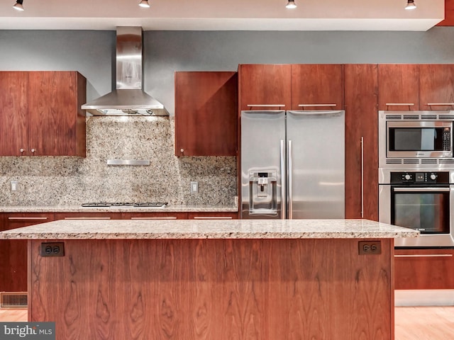 3411 Woodberry Ave, Baltimore, MD 21211 - kitchen featuring wall chimney exhaust hood, tasteful backsplash, visible vents, stainless steel appliances, and brown cabinets