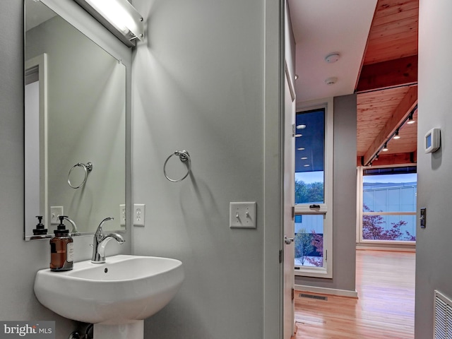 3411 Woodberry Ave, Baltimore, MD 21211 - bathroom featuring a sink, rail lighting, visible vents, wooden ceiling, and wood finished floors