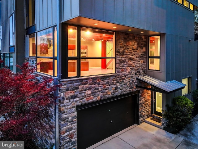 3411 Woodberry Ave, Baltimore, MD 21211 - doorway to property featuring driveway, stone siding, an attached garage, and board and batten siding
