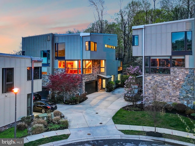 3411 Woodberry Ave, Baltimore, MD 21211 - view of front of house featuring concrete driveway, a garage, and stone siding