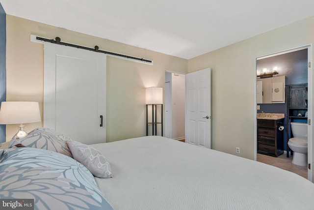 305 W Poplar Rd, Sterling, VA 20164 - bedroom with a barn door, ensuite bath, and a sink