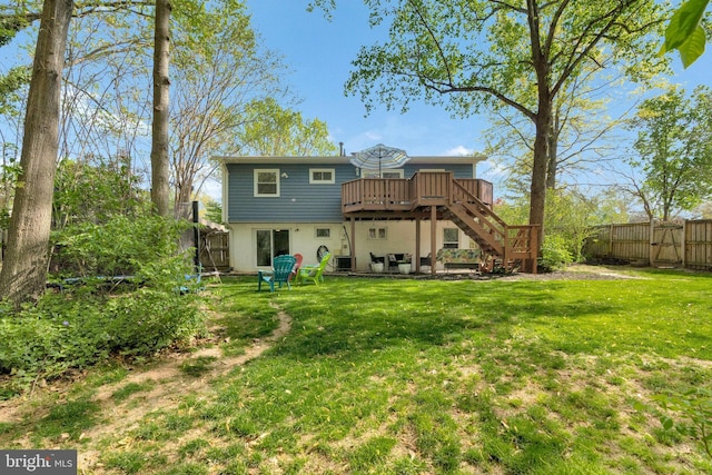 305 W Poplar Rd, Sterling, VA 20164 - rear view of property featuring a fenced backyard, a wooden deck, stairs, a yard, and stucco siding