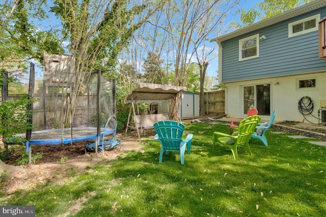 305 W Poplar Rd, Sterling, VA 20164 - view of yard with a fenced backyard, a storage unit, an outbuilding, and a trampoline