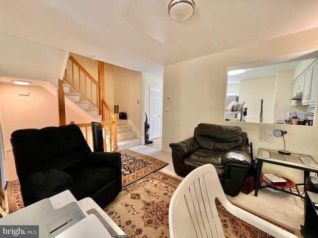 living area featuring stairway and light colored carpet