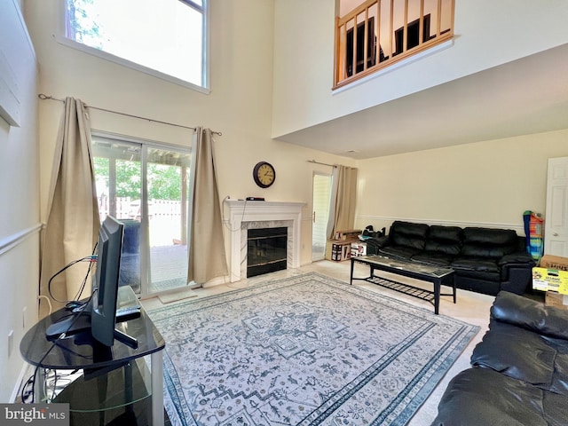 living area featuring a premium fireplace and a high ceiling