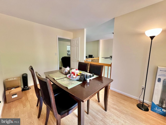 dining room featuring light wood-style flooring and baseboards