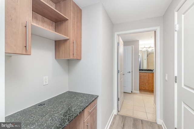 hall featuring baseboards and light wood-type flooring