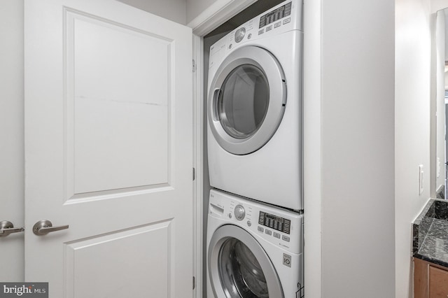 laundry room with stacked washer / drying machine and laundry area