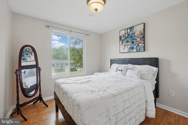 bedroom with wood finished floors and baseboards