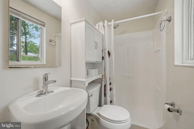 full bathroom featuring a sink, a shower with shower curtain, and toilet