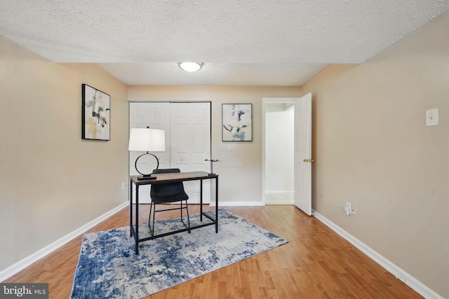 office featuring wood finished floors, baseboards, and a textured ceiling