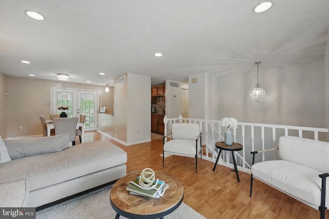 living area featuring light wood finished floors, recessed lighting, baseboards, and a chandelier