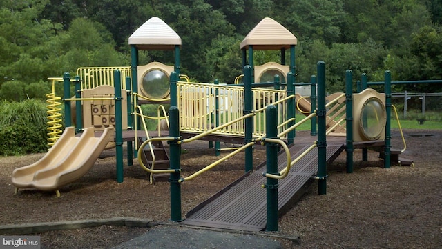 communal playground featuring a view of trees