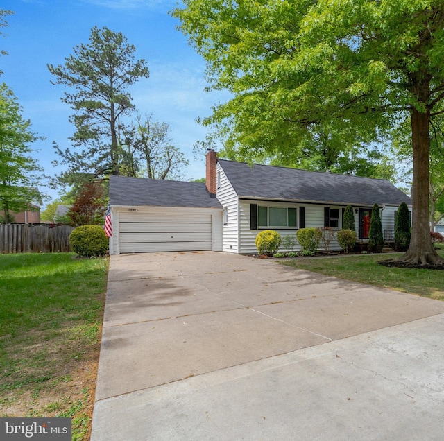view of front of home featuring a front yard, a garage, driveway, a chimney, and fence