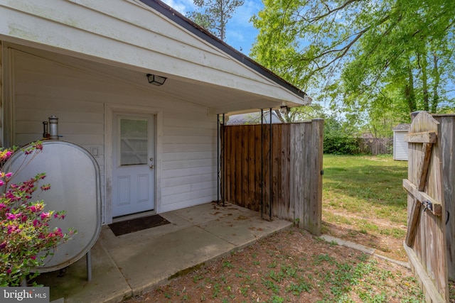 property entrance with fence, a yard, and heating fuel