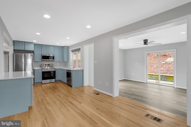 kitchen with light wood-style flooring, light countertops, visible vents, and stainless steel appliances