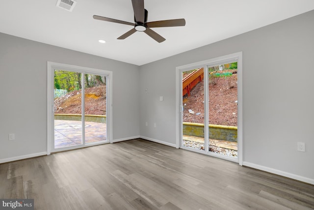 unfurnished room featuring wood finished floors, baseboards, and a ceiling fan