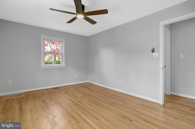 spare room featuring light wood-style flooring, baseboards, and a ceiling fan