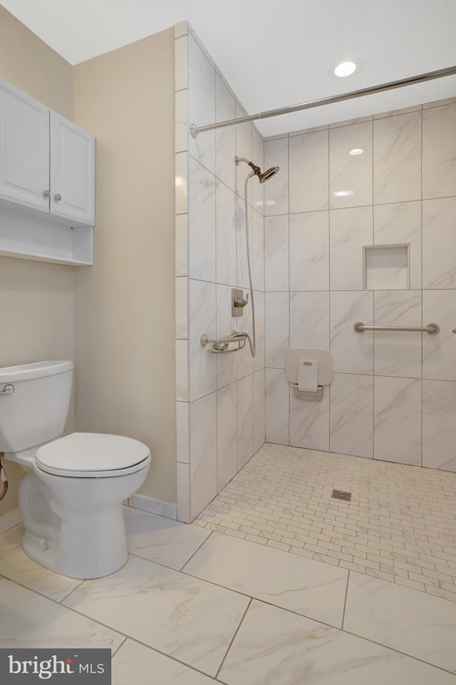 bathroom with toilet, tiled shower, marble finish floor, and baseboards