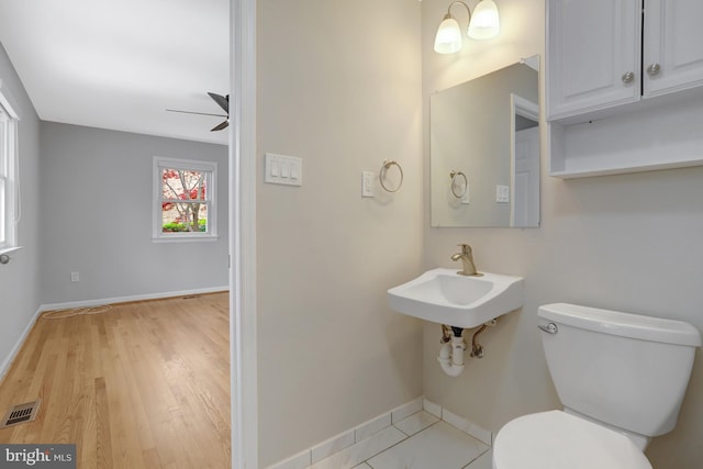 bathroom with visible vents, toilet, ceiling fan, and baseboards