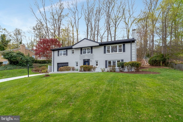 view of front of property featuring driveway, a front lawn, a chimney, and an attached garage