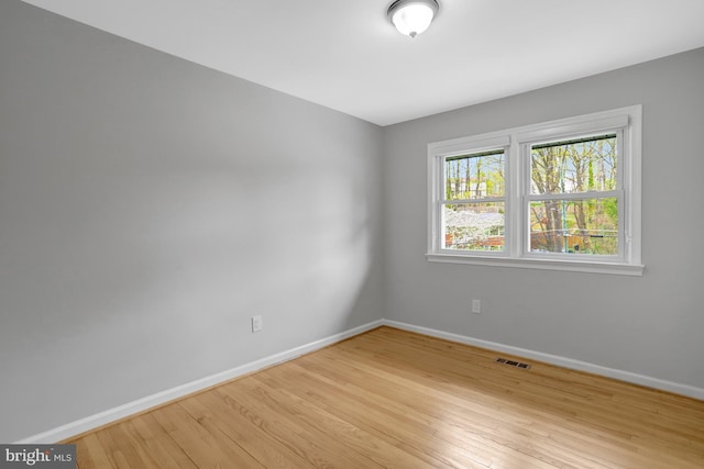 spare room with light wood-style flooring, baseboards, and visible vents