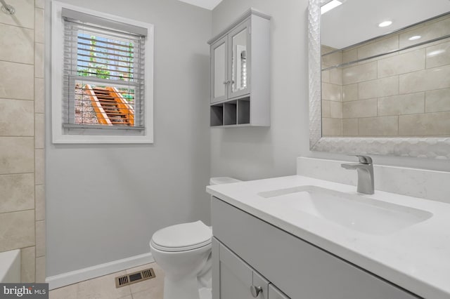 bathroom with visible vents, baseboards, toilet, vanity, and tile patterned floors