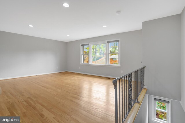 empty room featuring light wood-style flooring, baseboards, plenty of natural light, and recessed lighting