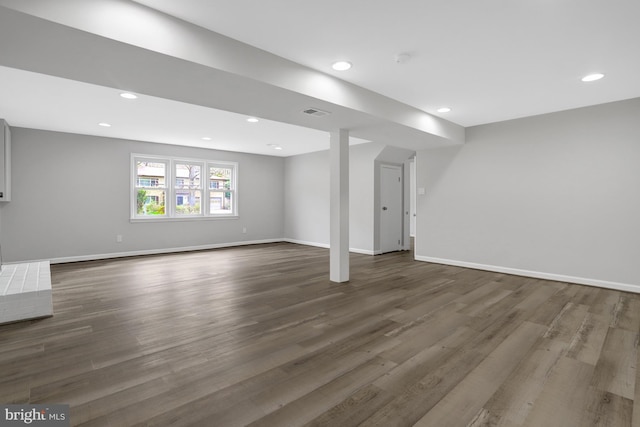 basement featuring recessed lighting, dark wood-type flooring, visible vents, and baseboards
