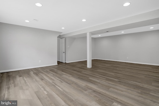 finished below grade area featuring wood finished floors, baseboards, visible vents, and recessed lighting
