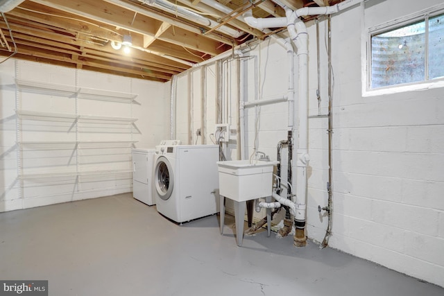 laundry room with a sink, washing machine and clothes dryer, and laundry area