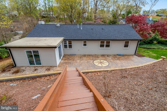 back of property featuring a patio and a shingled roof