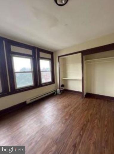 unfurnished bedroom featuring a closet, baseboards, and wood finished floors