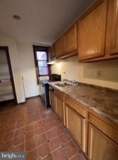 kitchen featuring a sink and brown cabinetry