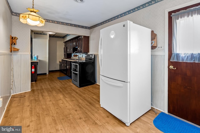 kitchen with light wood finished floors, freestanding refrigerator, a wainscoted wall, double oven range, and dark brown cabinetry