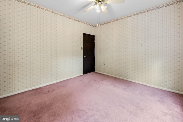 carpeted empty room with a ceiling fan and baseboards