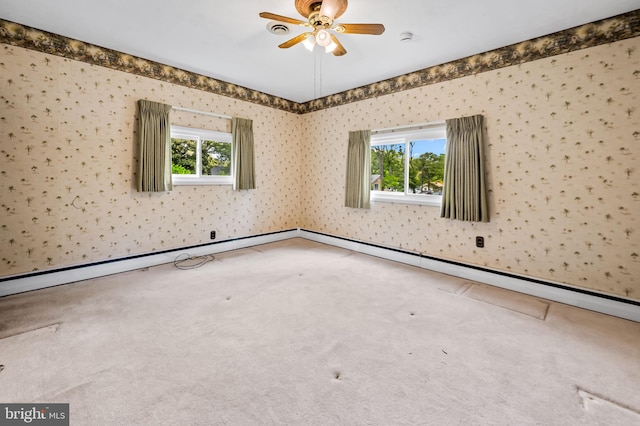 carpeted empty room with a ceiling fan, a healthy amount of sunlight, and wallpapered walls