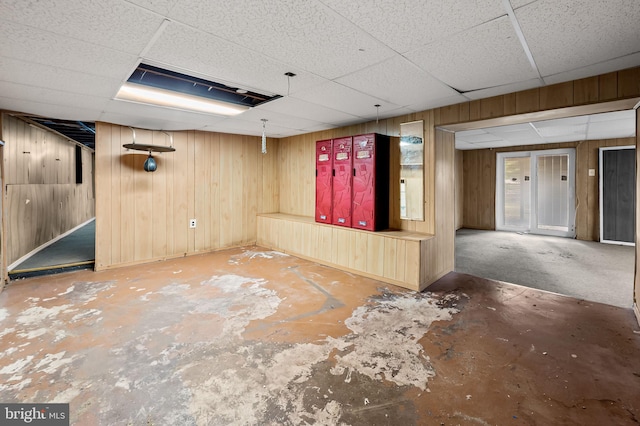 finished below grade area with wooden walls and a paneled ceiling