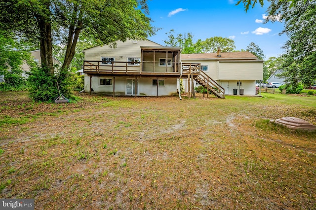 rear view of property with stairway, a deck, fence, and a lawn