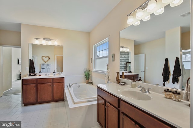 bathroom featuring two vanities, a whirlpool tub, a sink, and visible vents