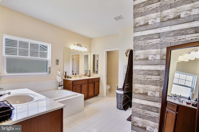 full bath featuring tile patterned flooring, wooden walls, visible vents, a sink, and two vanities