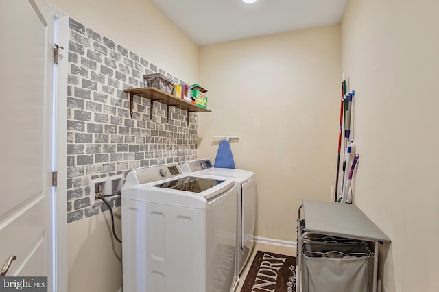 laundry area featuring baseboards, washer and clothes dryer, and laundry area