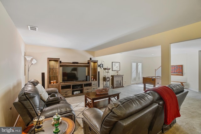 living room featuring light carpet, visible vents, and baseboards