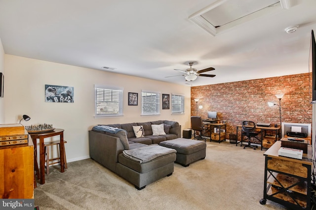 living area with visible vents, carpet floors, baseboards, brick wall, and ceiling fan