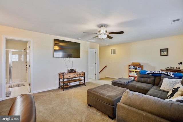 living area featuring light carpet, a ceiling fan, visible vents, and baseboards