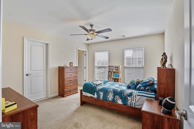 carpeted bedroom with ceiling fan and visible vents